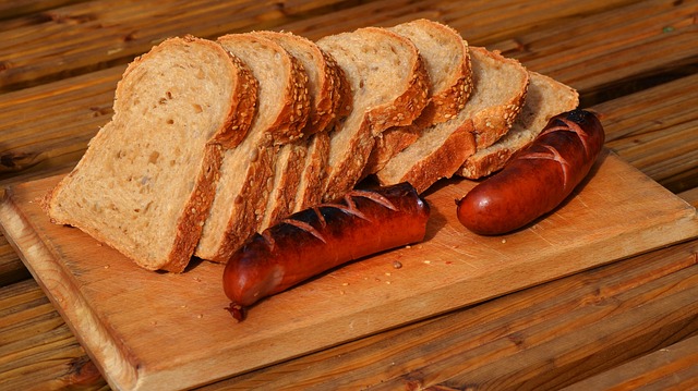 kiełbasa zwyczajna z artykułu o wędzonej kiełbasie zwyczajnej, podana wraz z chlebem razowym na drewnianej desce